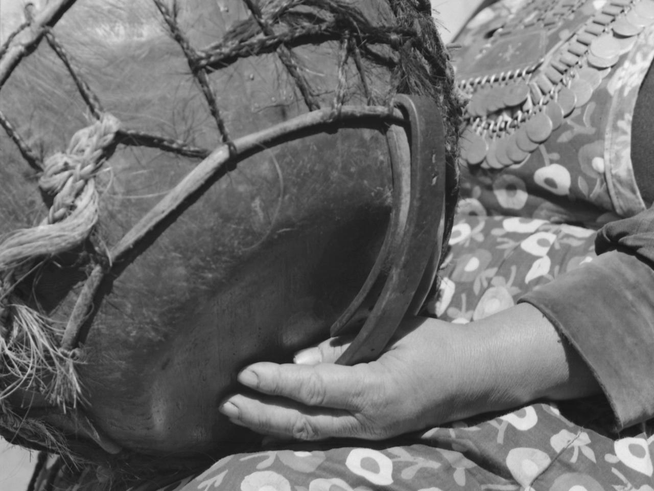 Temuco: Mujer mapuche (Amiga de Cardoso) sentada afuera de su ruca que tiene en la pared un afiche que dice: &amp;quot;Piensen compañeros que el Consejo Comunal es el único camino&amp;quot;. Sentada afuera de su ruca tocando un kultrú, con sus collares de plata; desta